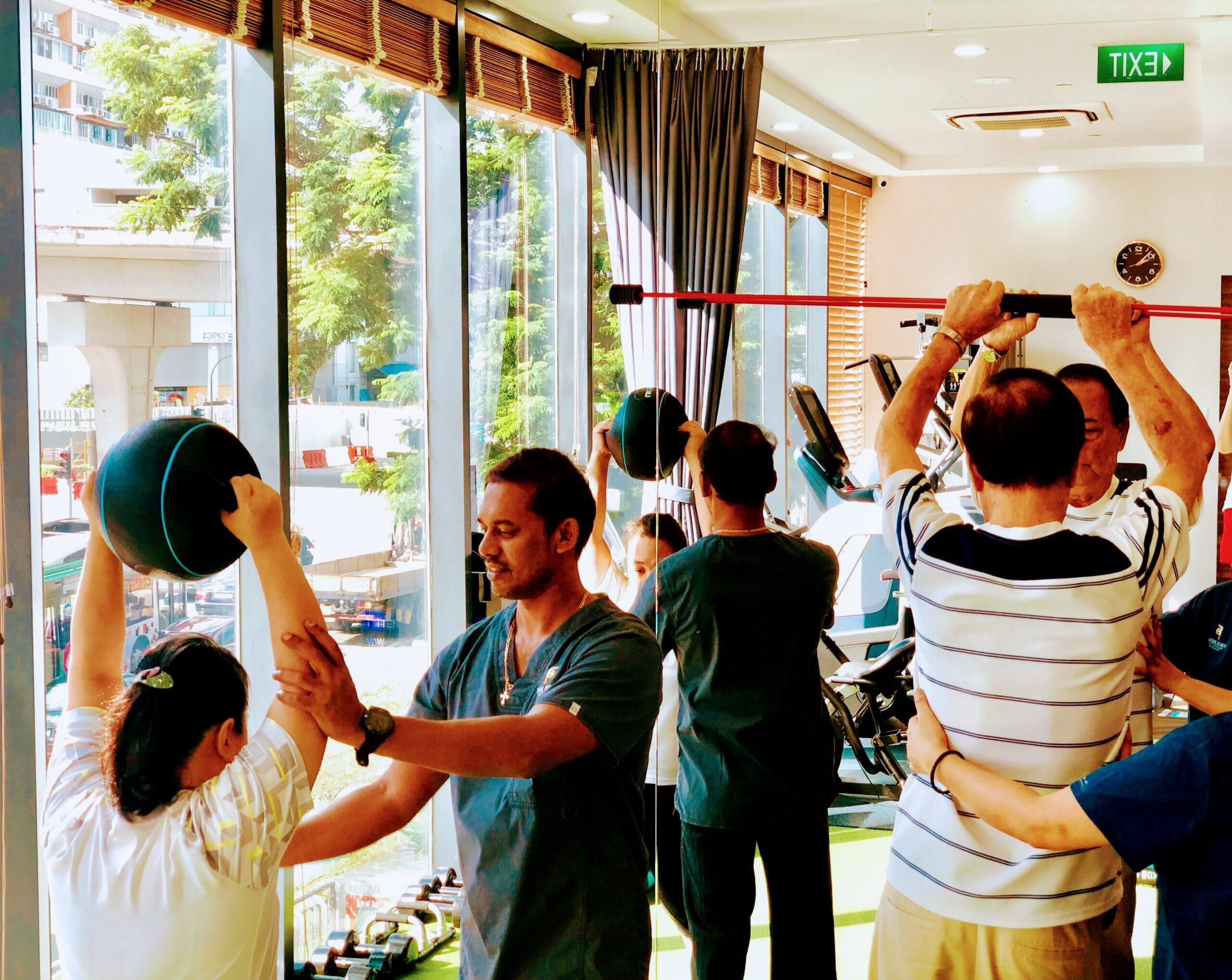 Our team of physiotherapists assisting patients with exercises in a gym