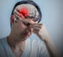 Person holding forehead in pain, eyes closed