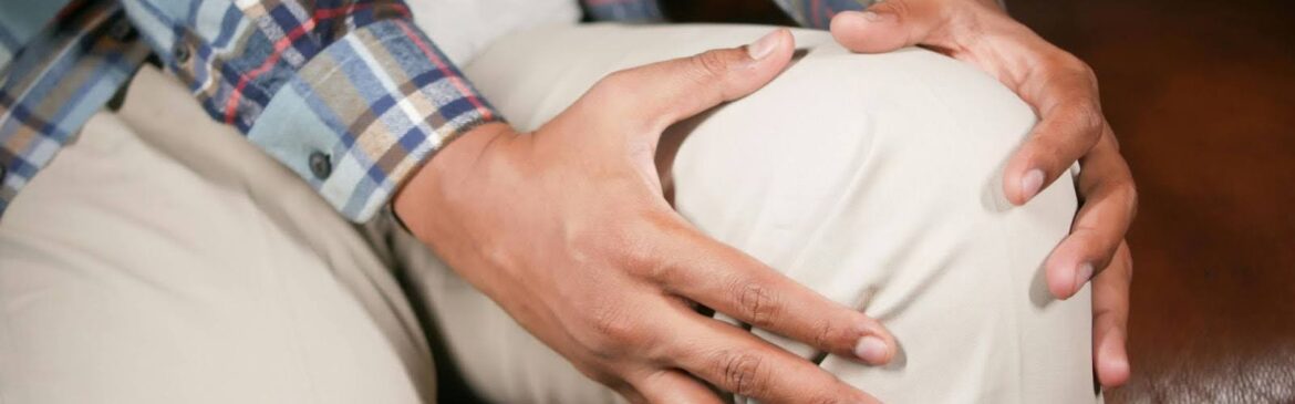A person holding his knee indicating pain