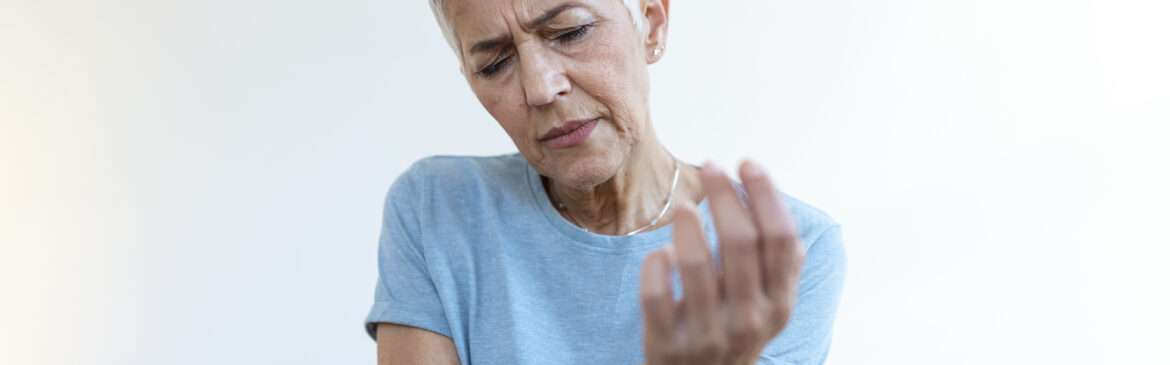 Elderly woman suffering from hand arthritis