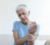 Elderly woman suffering from hand arthritis