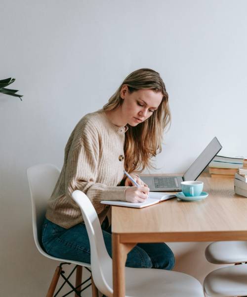 A person exercises indoors, focusing on their leg wrapped in blue and green kinesiology tape