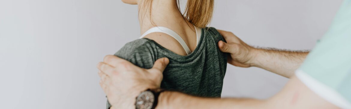 A physiotherapist correcting the posture of the woman