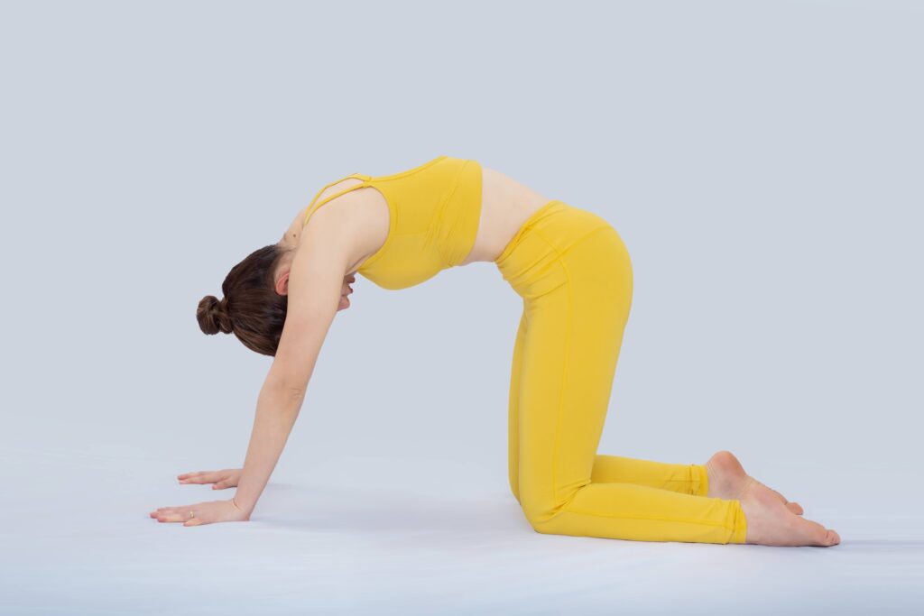 a woman on her hands and knees doing the cat-cow stretch