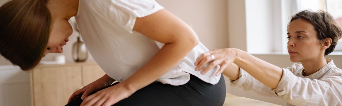 A physiotherapist checking the back pain of a patient