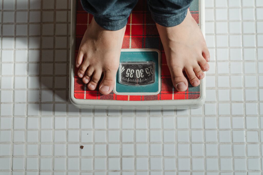 A man checking his weight in a weighing scale
